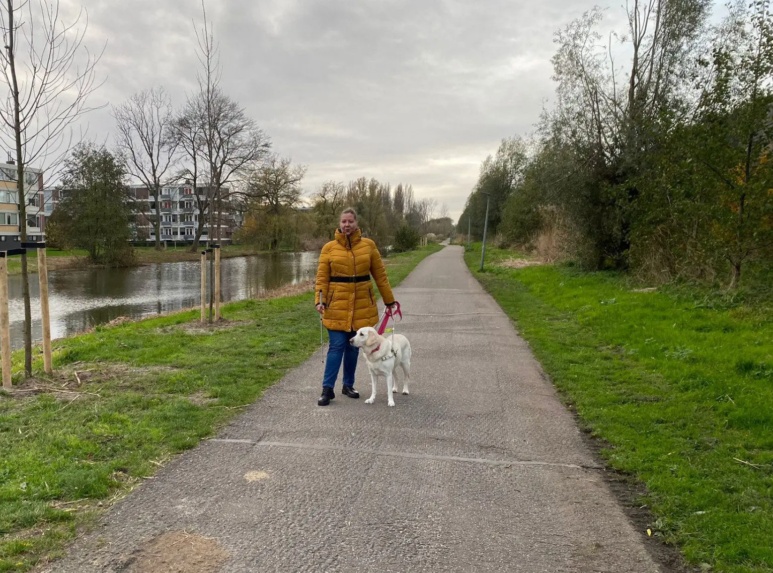 Desiree loopt buiten met haar blindengeleidehond Olivia