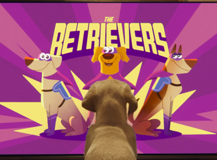 pup kijkt naar still uit de animatievideo waarbij 3 getekende retrievers als superheld te zien zijn