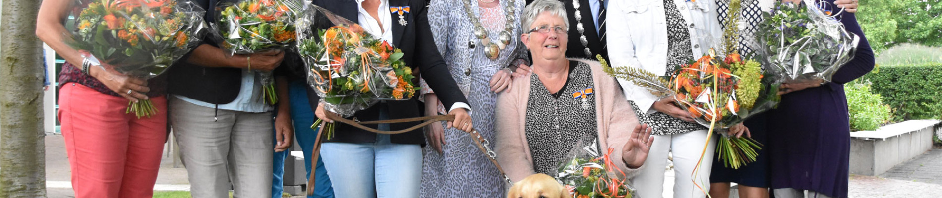 Groepsfoto van vrijwilligers van KNGF Geleidehonden met een onderscheiding en de burgemeester