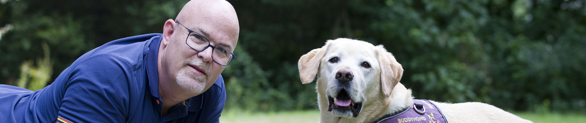 Blonde hond en baasje liggen in het gras