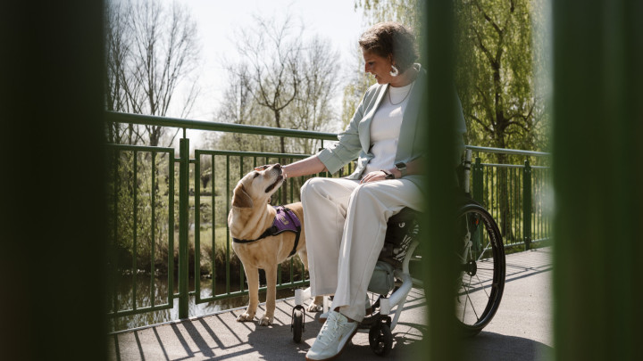 Cliënt Diana aait ADL-assistentiehond Osja