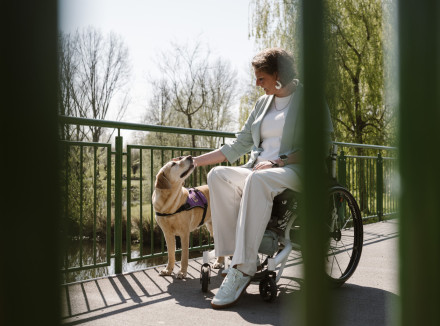 Cliënt Diana aait ADL-assistentiehond Osja