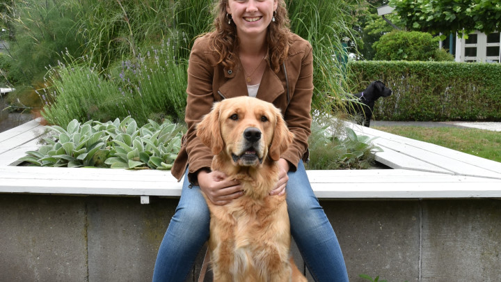 Portretfoto van Janice met haar golden retriever Urley op een bankje bij KNGF