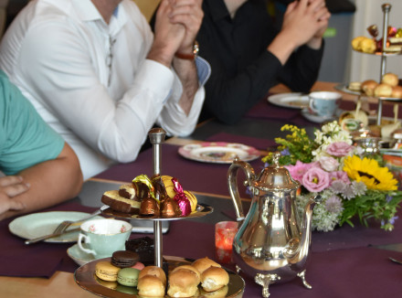 Puppypleeggezinnen zitten aan tafel met hapjes tijdens verwenmiddag