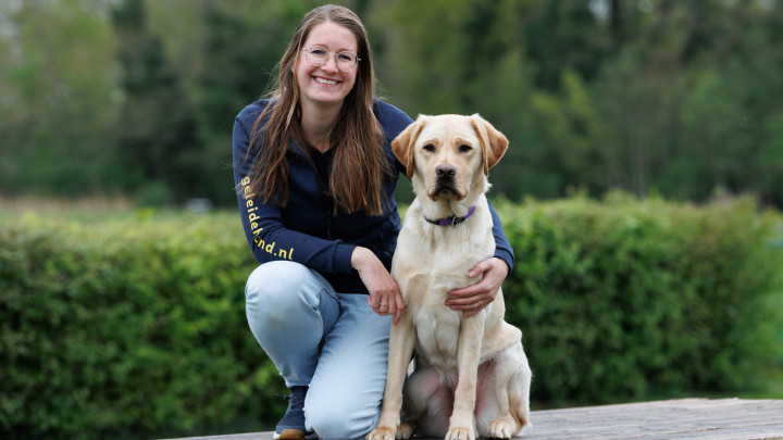 portretfoto van collega Sabine met een blonde hond naast haar