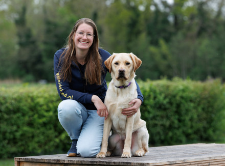 portretfoto van collega Sabine met een blonde hond naast haar