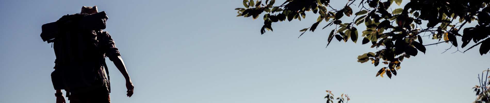 silhouette van een man die buiten loopt met een blauwe lucht