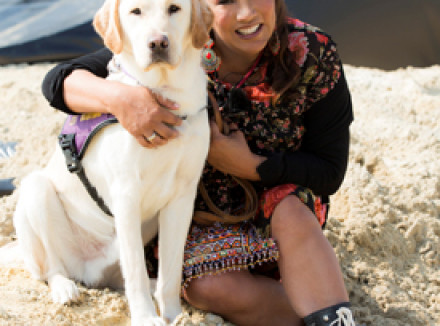 Presentatrice Patty Brard zit naast een geleidehond in opleiding