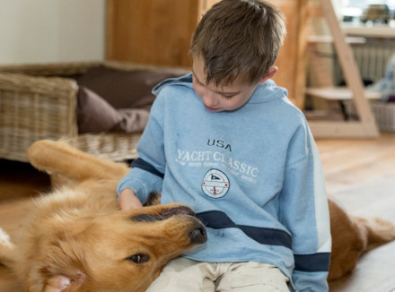 Jongetje knuffelend met zijn buddyhond autisme