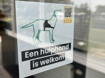 deur met 'hulphond is welkom' sticker