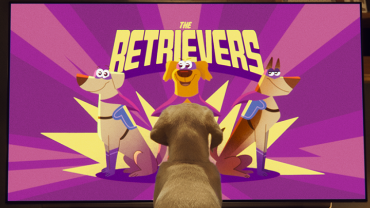 pup kijkt naar still uit de animatievideo waarbij 3 getekende retrievers als superheld te zien zijn