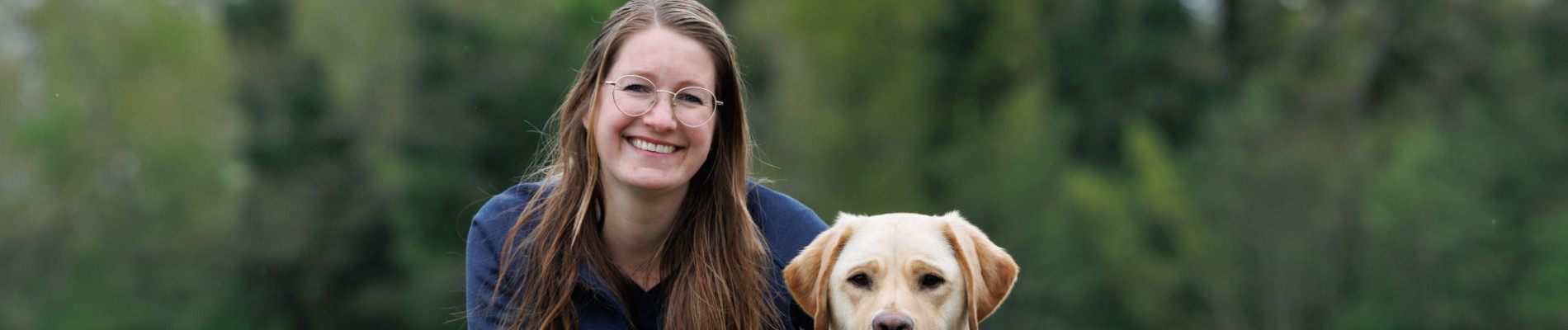 portretfoto van collega Sabine met een blonde hond naast haar