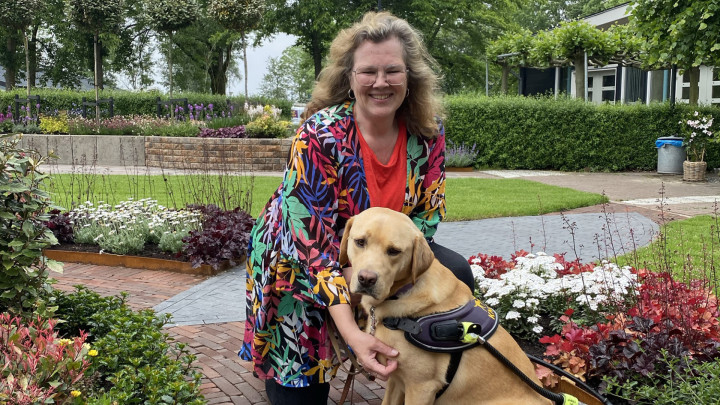 Client Martine en haar geleidehond Giggles in de vernieuwde fleurige tuin
