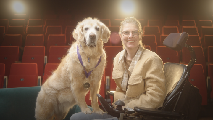 Sandra in rolstoel met Babbe naast zich in een theater
