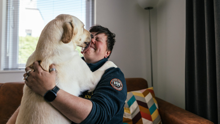 Blonde hond likt in gezicht van trainer