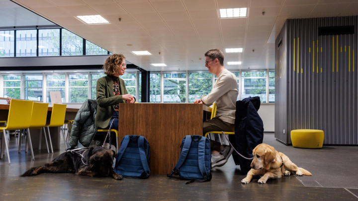 Femke en Tom samen met hun geleidehond op school