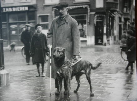 oude zwart-wit foto van een man met zijn geleidehond