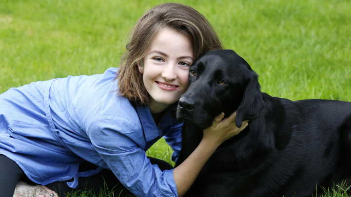 Meisje en haar buddyhond samen in het gras