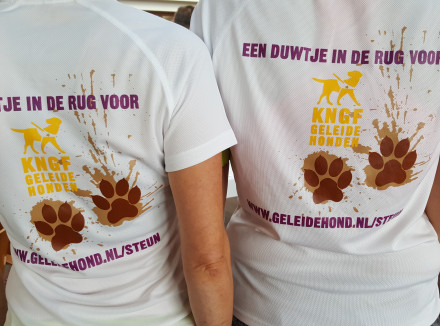 KNGF-hardloopshirts van deelnemers aan Dam- tot Damloop met daarop modderpootjes en Een duwtje in de rug voor de geleidehond