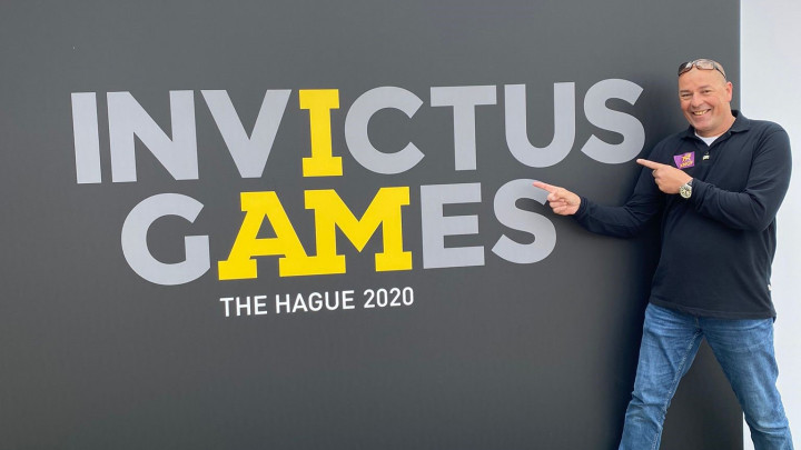 Niels naast een groot logo van Invictus Games