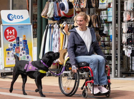 Nynke in een rolstoel in een winkelstraat en Jissa loopt naast haar