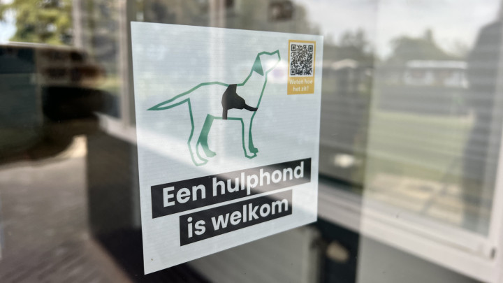 deur met 'hulphond is welkom' sticker