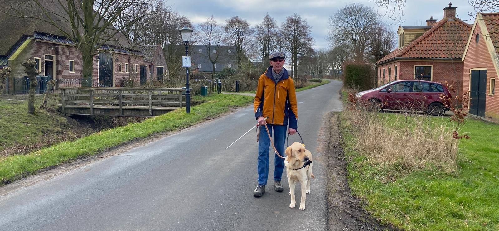Albert en zijn geleidehond op een landelijke weg