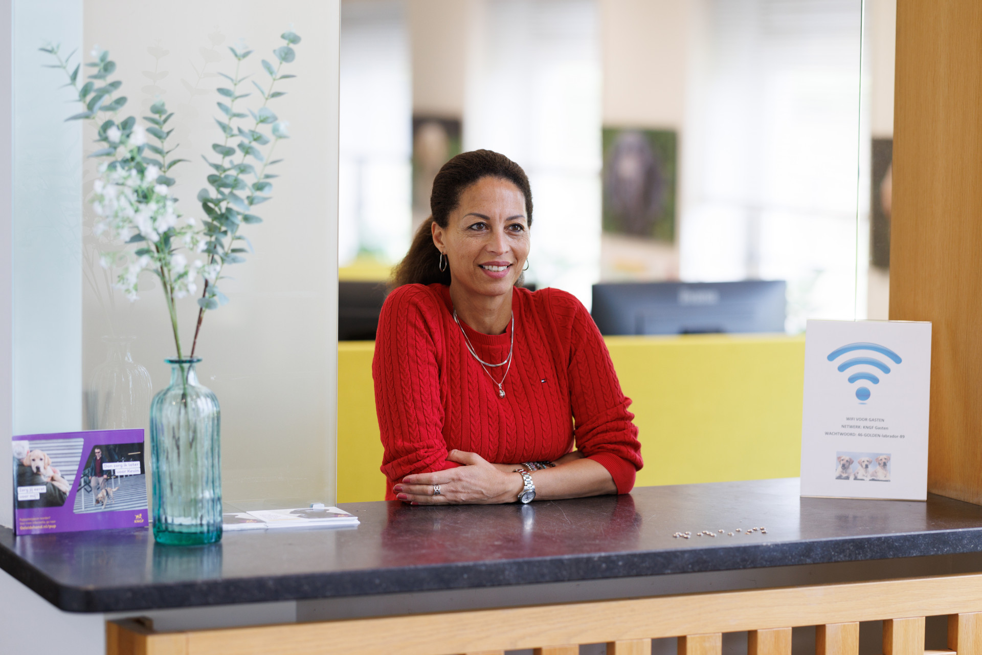 Maureen staat achter de balie bij de receptie