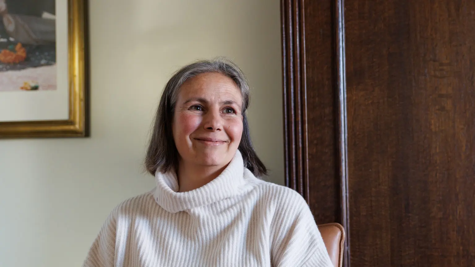 Cristel poseert voor de camera in haar woonkamer wanneer zij vertelt dat zij KNGF heeft opgenomen in haar testament
