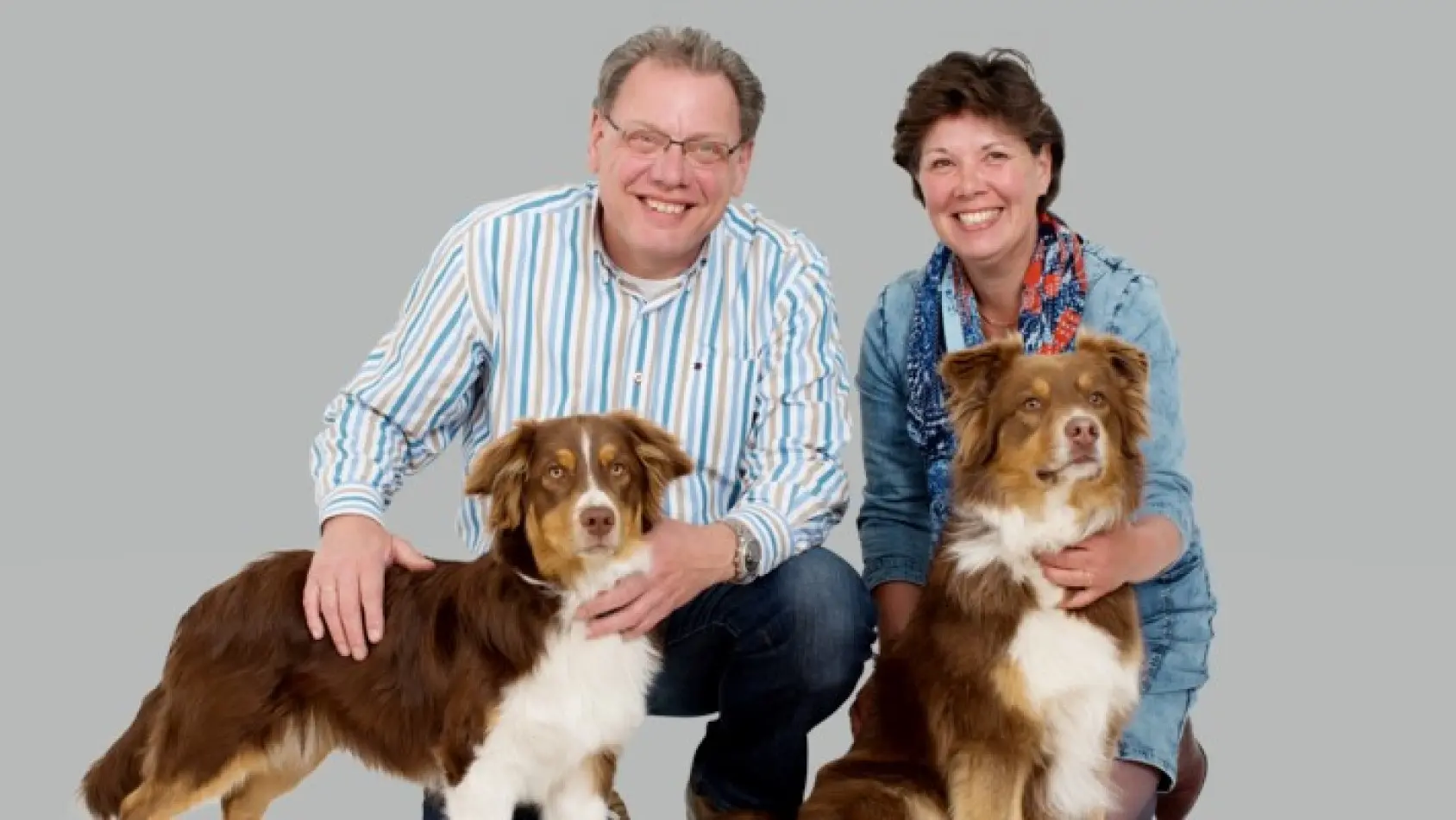 Rob en Sylvia met hun eigen honden poserend met grijze achtergrond