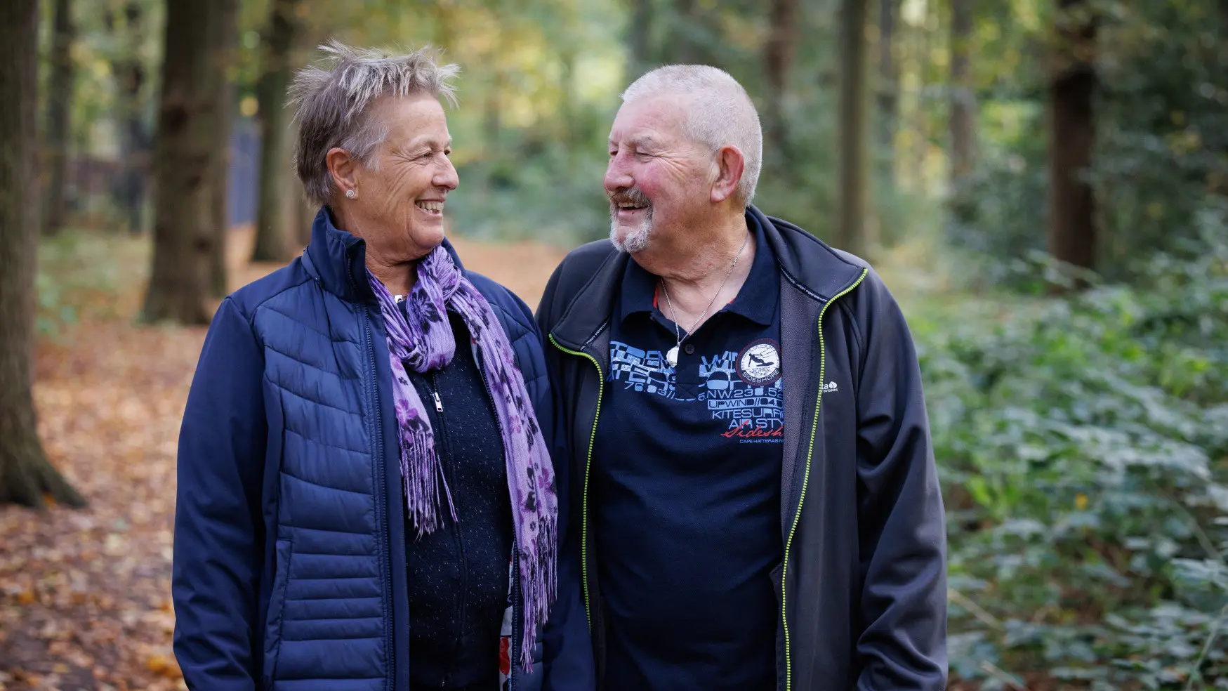 Gert en Agta wandeld door een bos, naar elkaar kijkend