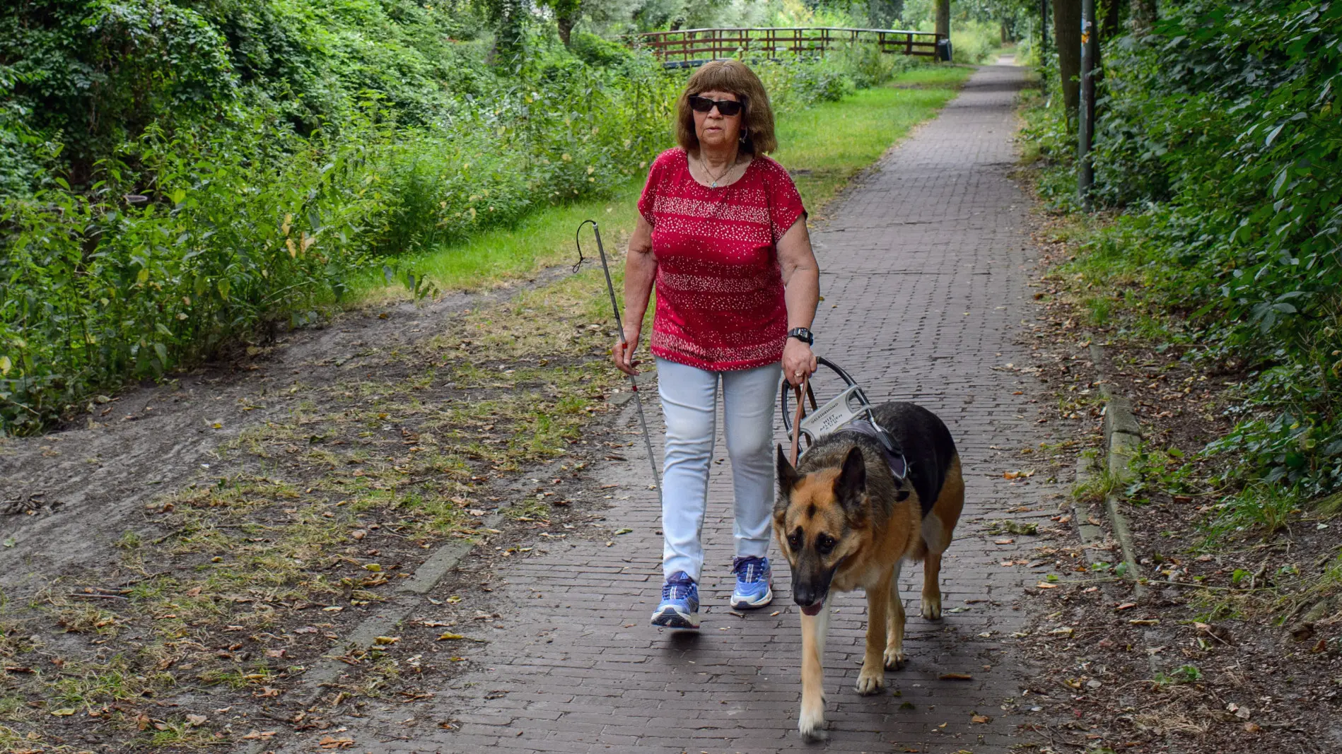 Wil loopt buiten met haar blindengeleidehond Kate, een duitse herder