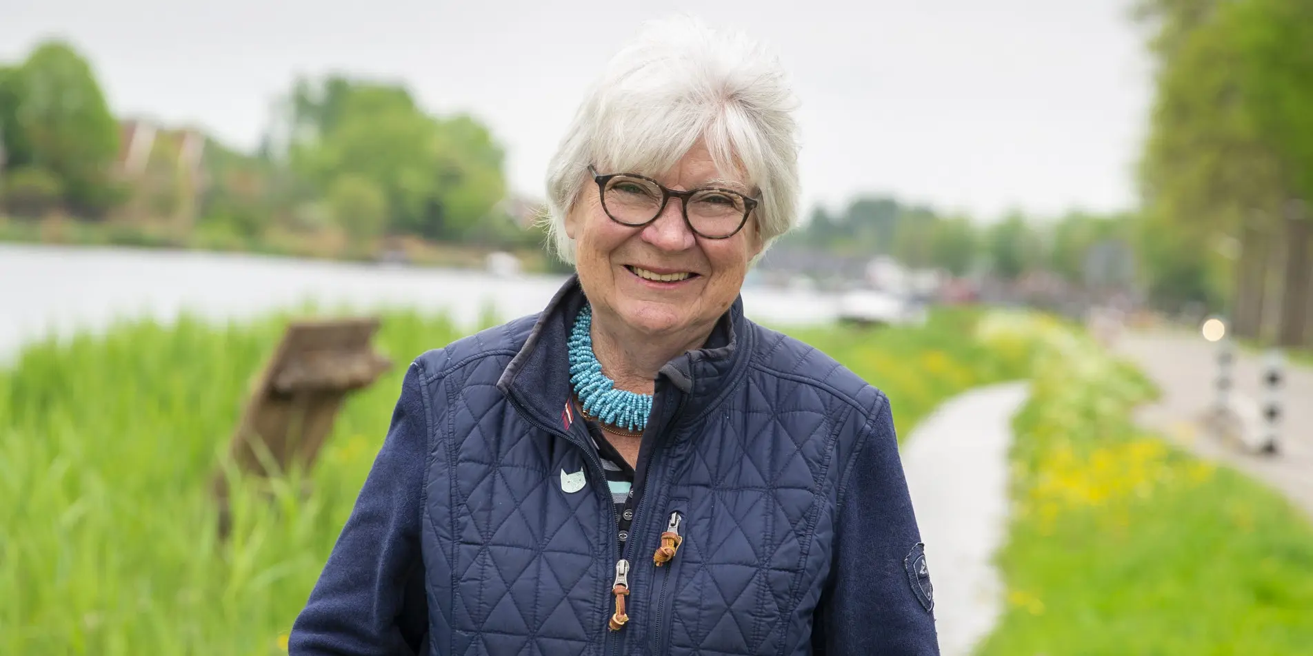 Donateur Loes poseert voor de camera met op de achtergrond een kanaal