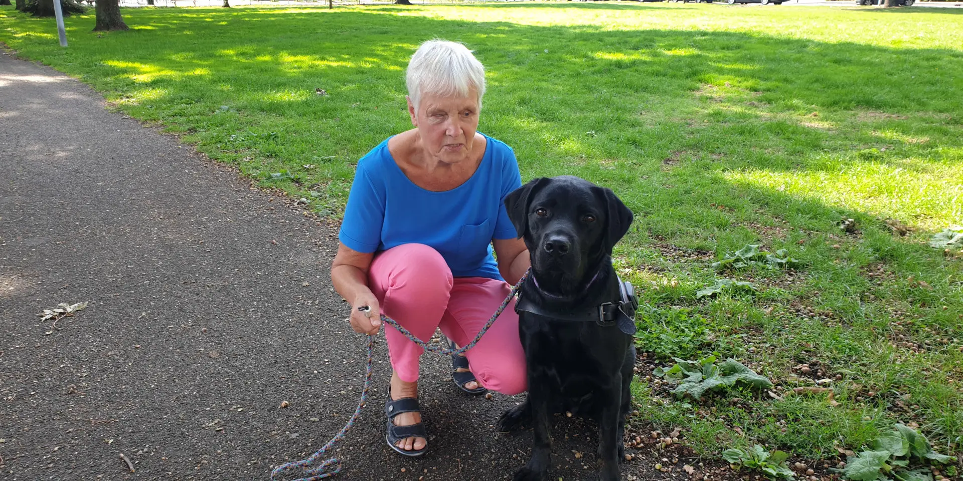 Hennie met haar hulphond, een zwarte labrador