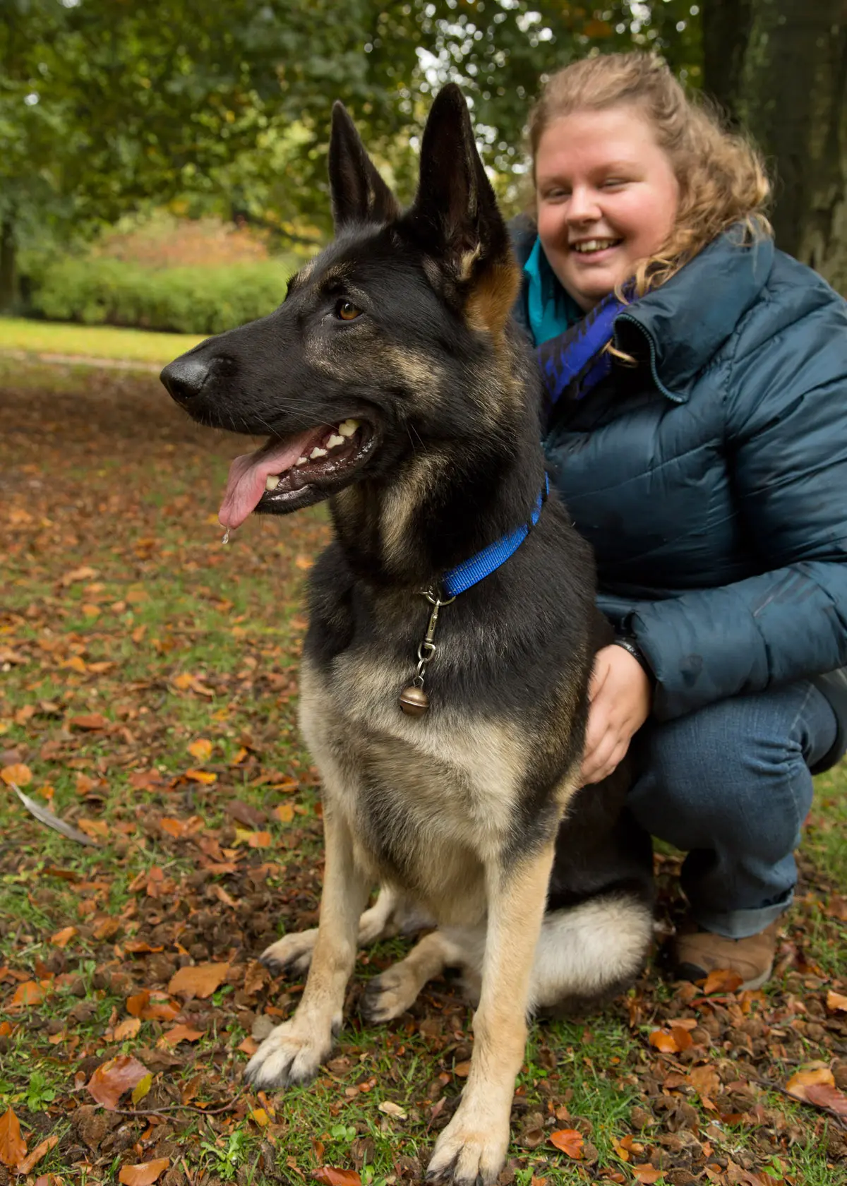 Marleen zit samen met haar geleidehond Tessie in een herstachtige bosomgeving