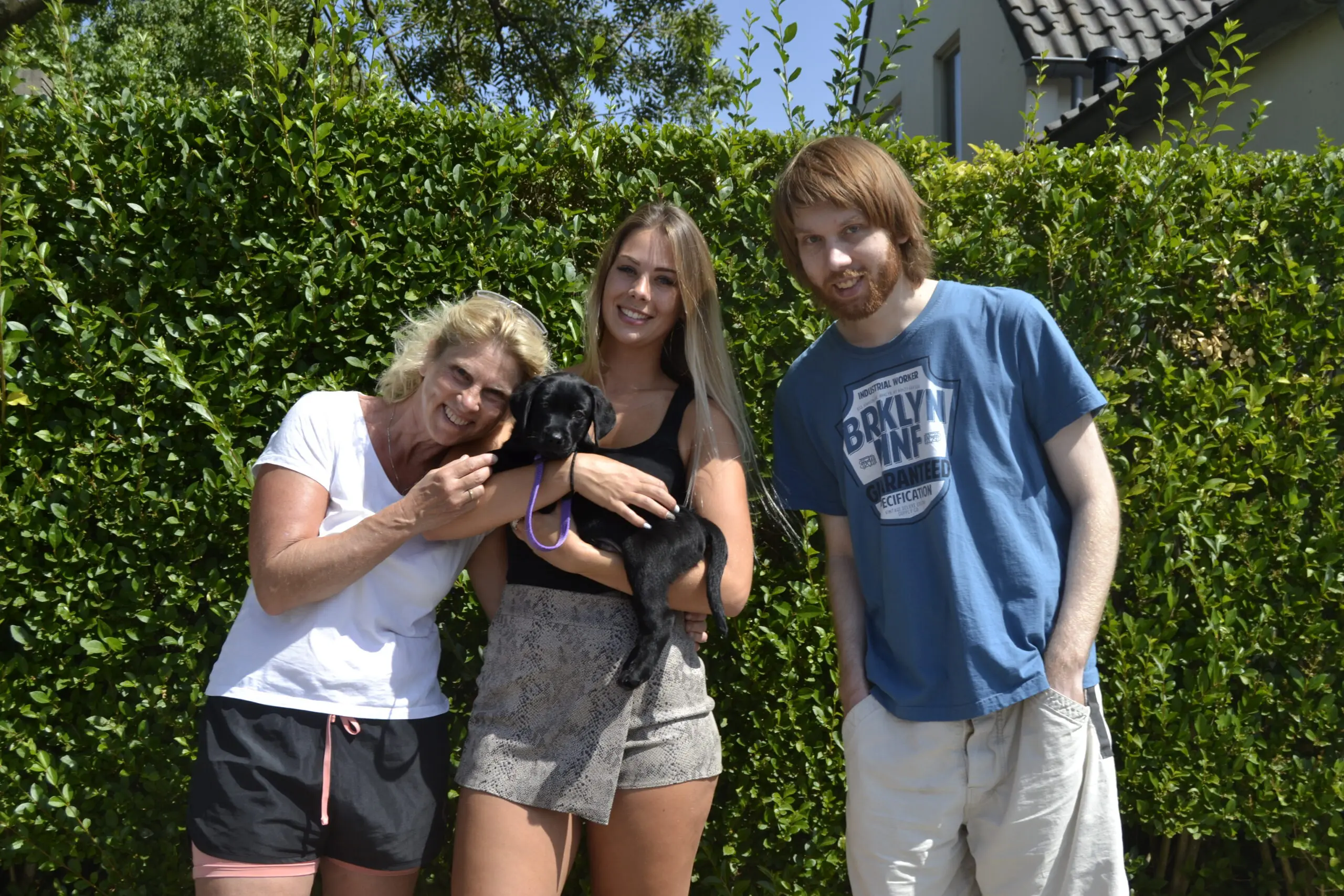De familie Fritz met hun KNGF pup Mack, een zwarte labrador