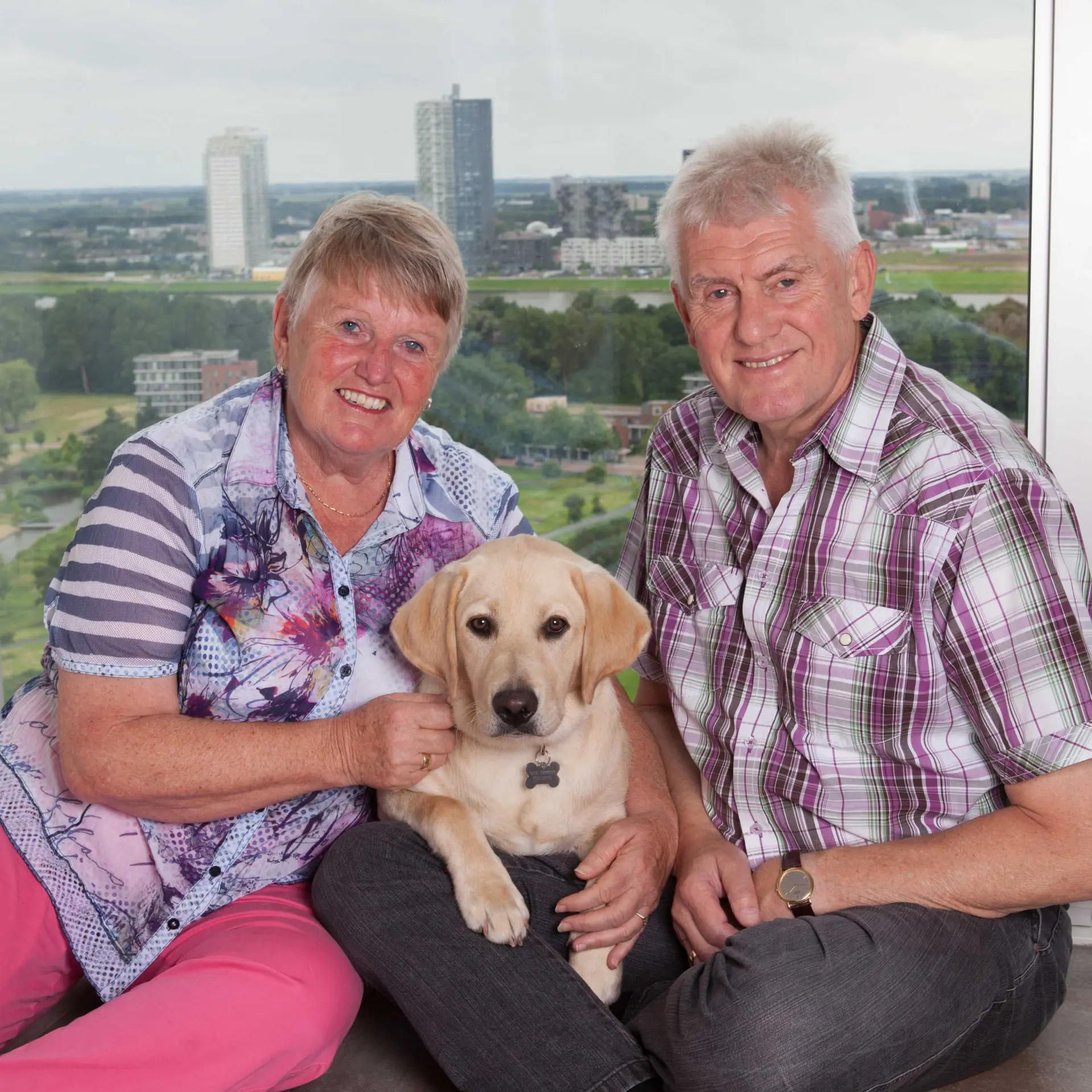 Cor en Joke samen met hun pup met op de achtergrond de stad Rotterdam