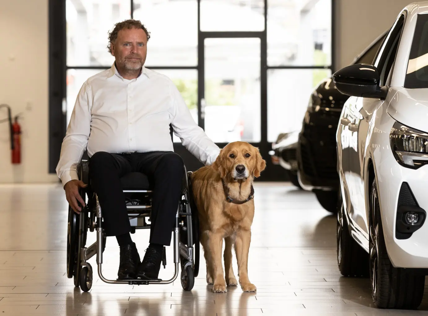 Pieter en Guinness samen in de showroom van de autozaak