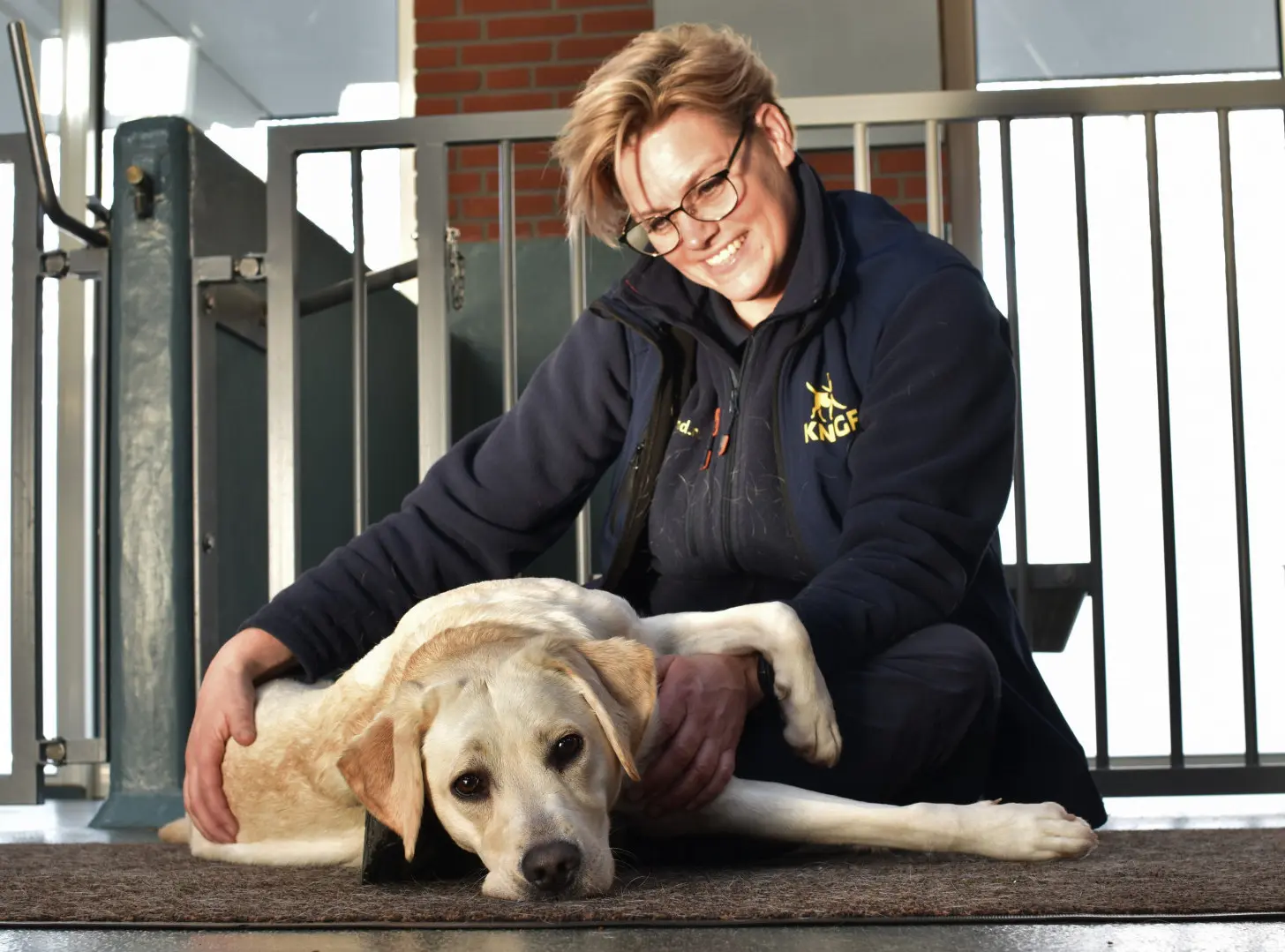 Rafa geeft hulphond in opleiding Mira een massage terwijl zij er ontspannen bij ligt