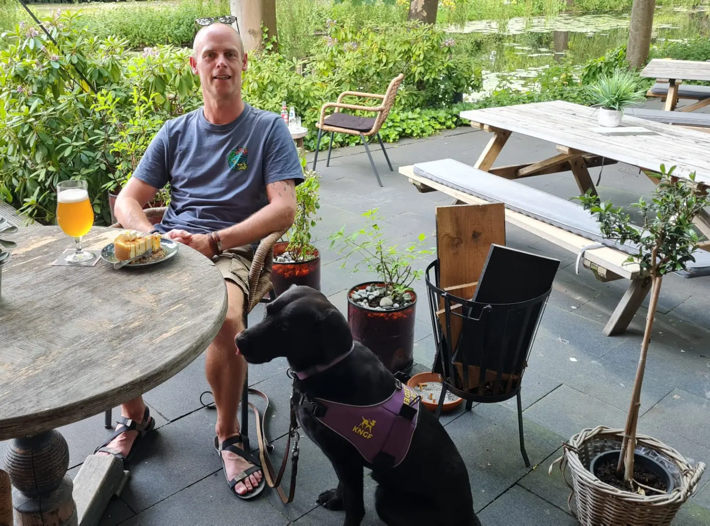 Peter-Paul met zijn PTSS assistentiehond Zowie op het terras