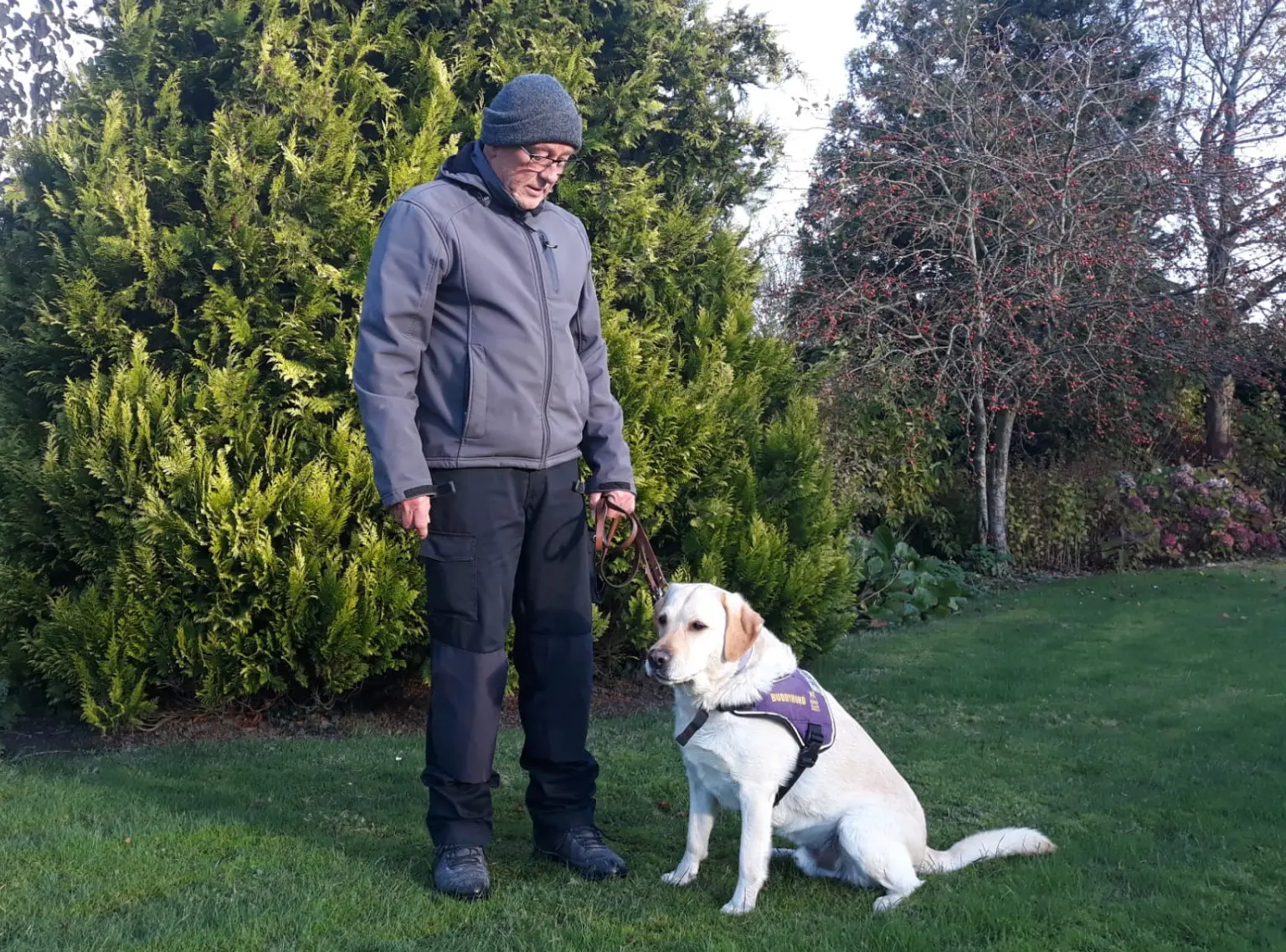 Jan en zijn PTSS assistentiehond Bouba in de tuin