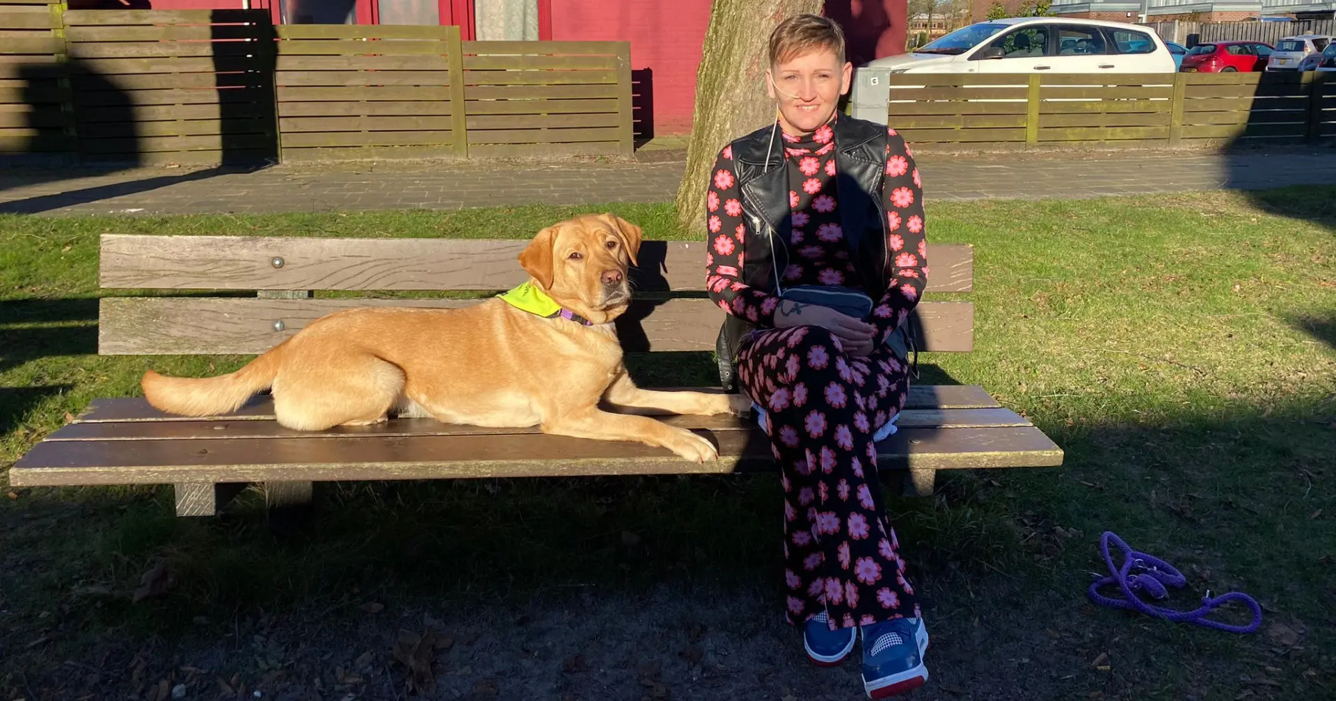 Klaske en haar assistentiehond Lobke zittend op een bankje in de zon