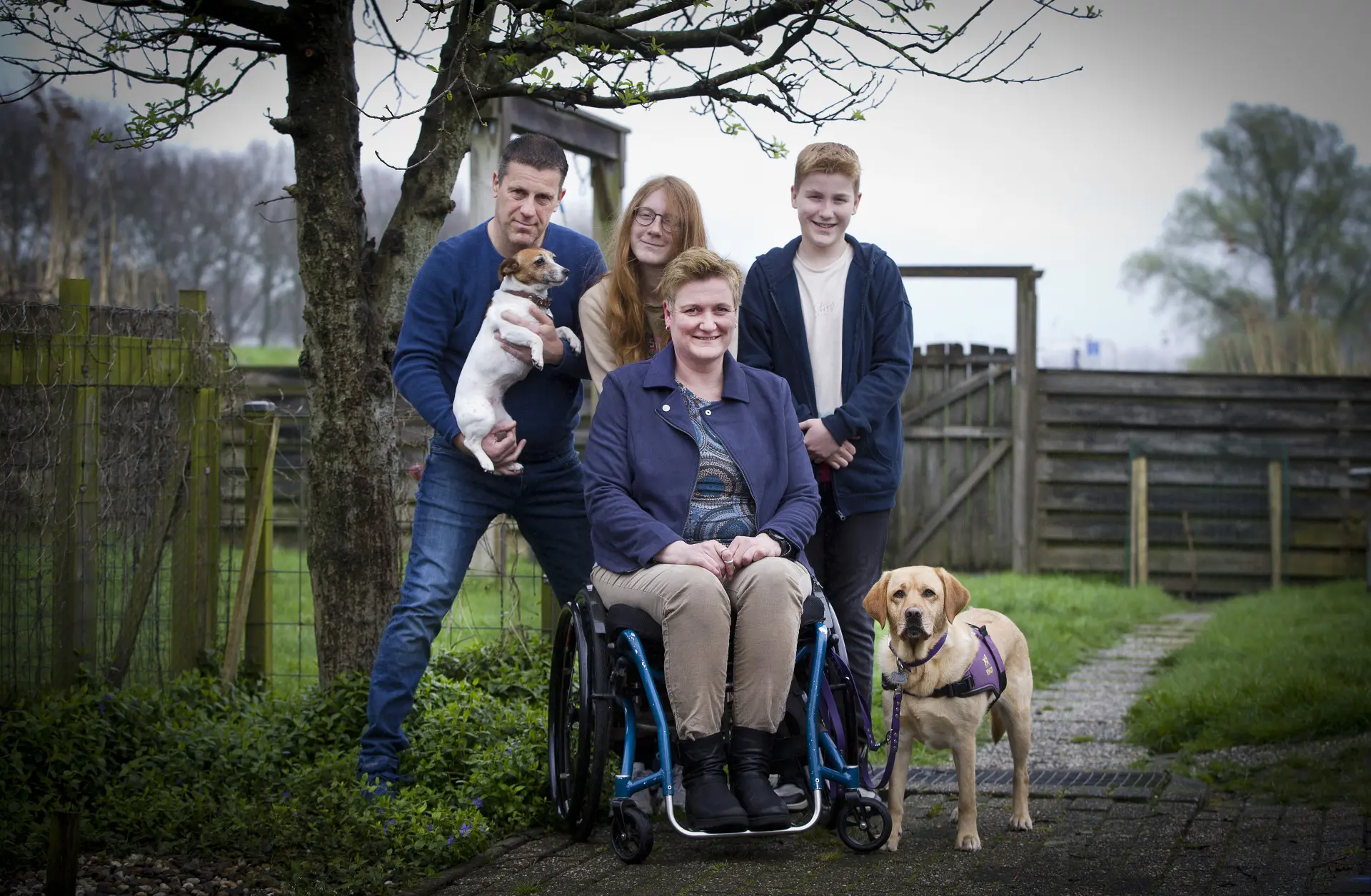 Cindy poseert in de tuin samen met het hele gezin en assistentiehond Danja