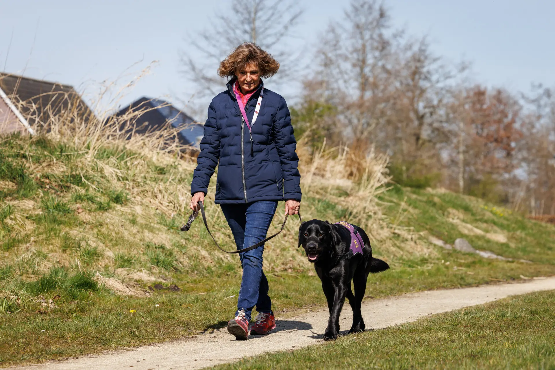 Mellina en haar PTSS assistentiehond Lyos wandelen buiten in de duinen