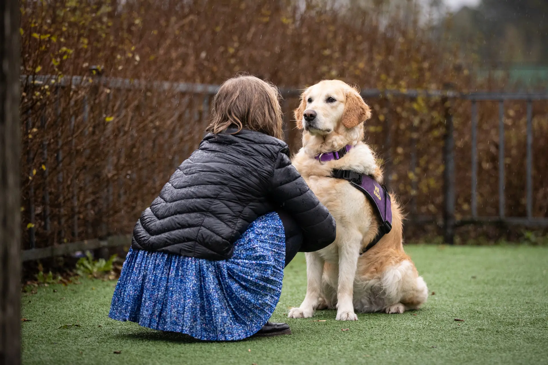 Isa met haar buddyhond Vespa zitten buiten en kijken elkaar indringend aan