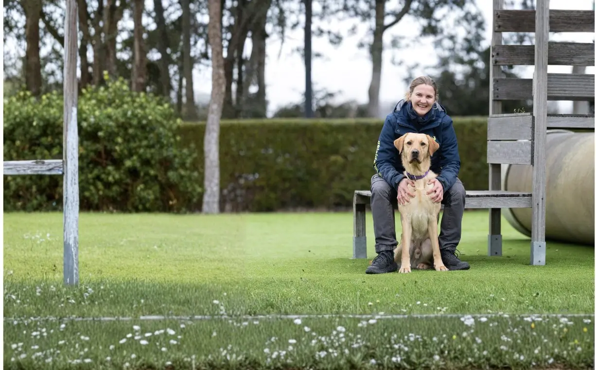 Hulphond in opleiding Gimli samen met Annemieke zittend op een houten bank