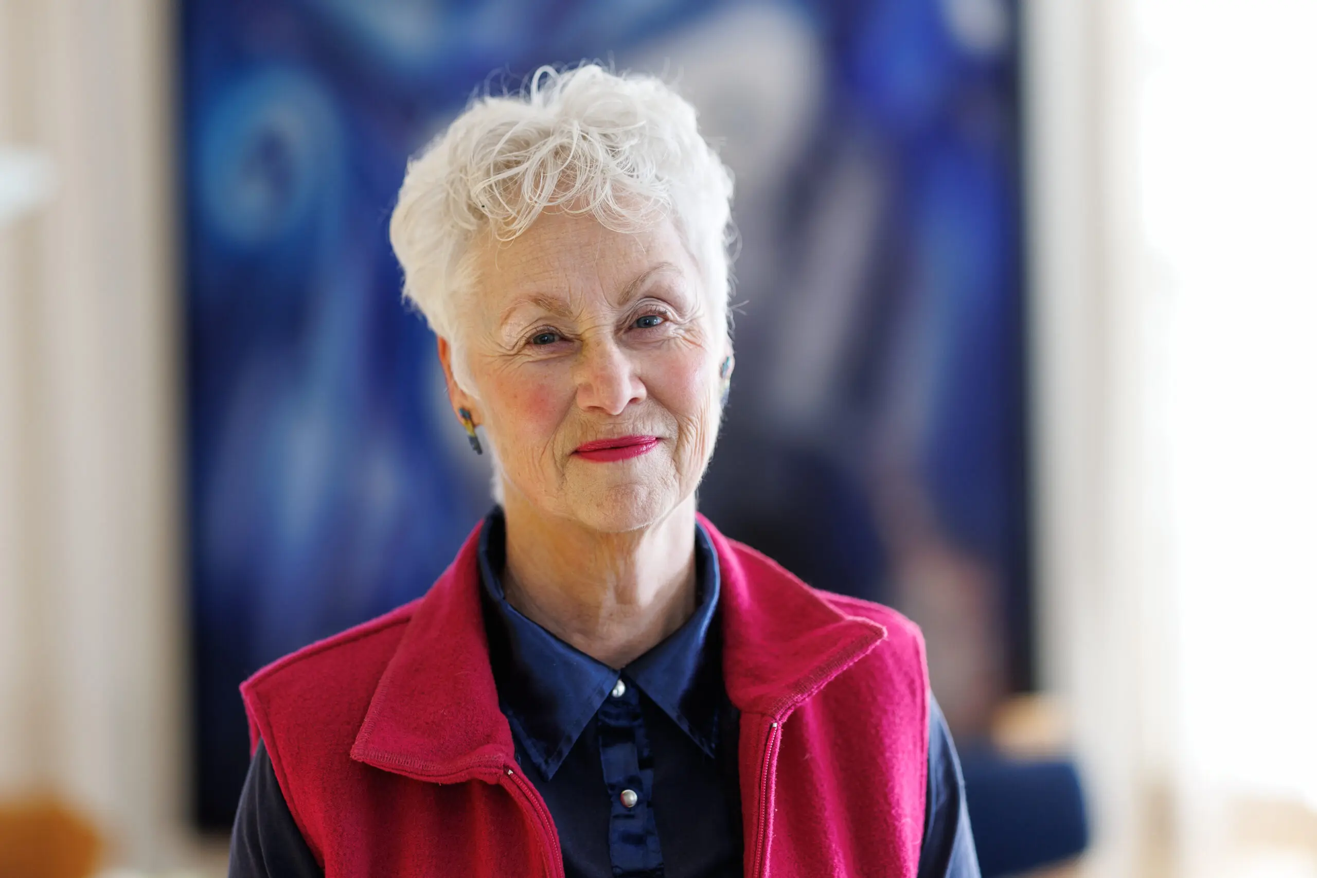 portret van een vrouw met kort grijs haar en kleurrijke kleding aan