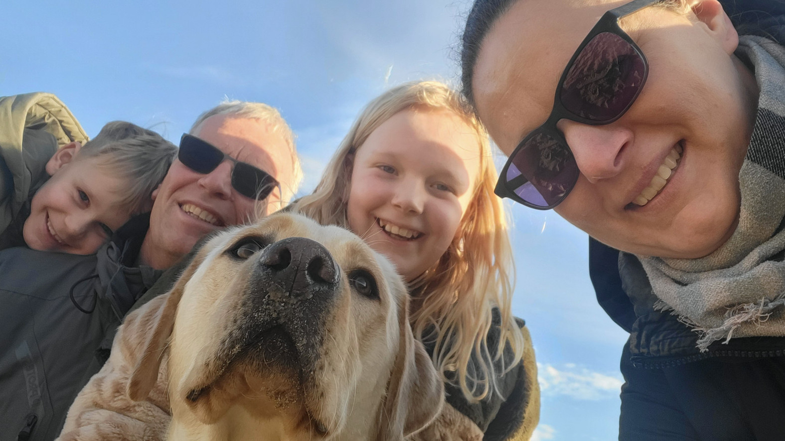 Familie Volwater samen met de toekomstige hulphond Vee-Jay, de camera is van onderaf gericht