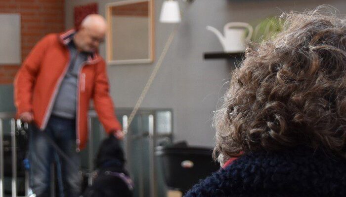 Ans en haar zussen luisteren aandachtig naar een verhaal van een client met zijn hulphond