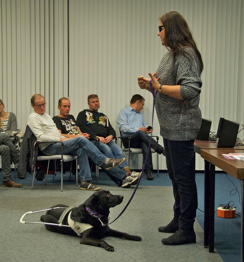 Ambassadeur Anne spreekt tegenover een publiek dat aandacht luistert